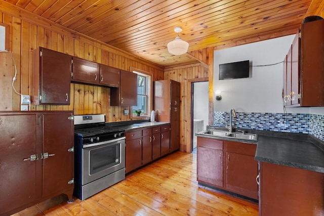 8001 S Jackson Rd, Jackson, MI 49201 - kitchen with gas stove, a sink, dark countertops, wooden walls, and wood ceiling