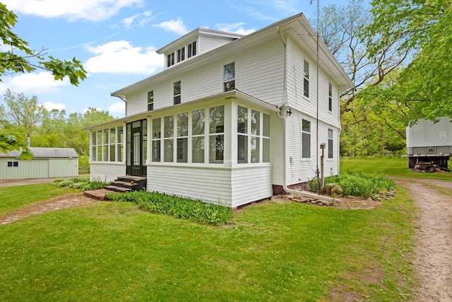 8001 S Jackson Rd, Jackson, MI 49201 - view of home's exterior featuring entry steps, a yard, dirt driveway, and a sunroom