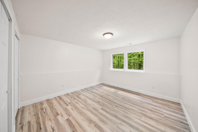 64711 Shorewood Ln, Cassopolis, MI 49031 - unfurnished bedroom with light wood-style flooring, a closet, baseboards, and a textured ceiling