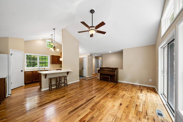 64711 Shorewood Ln, Cassopolis, MI 49031 - unfurnished living room featuring high vaulted ceiling, light wood-style flooring, a ceiling fan, baseboards, and a sink