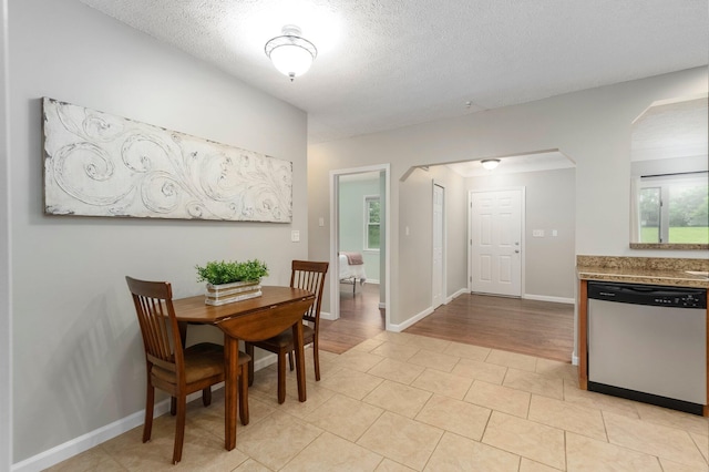 4121 Quebec St, Auburn Hills, MI 48326 - dining area with arched walkways, a textured ceiling, baseboards, and light tile patterned flooring