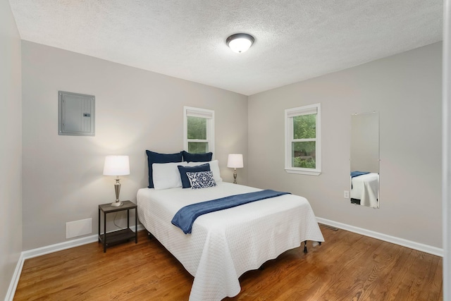 4121 Quebec St, Auburn Hills, MI 48326 - bedroom featuring electric panel, wood finished floors, baseboards, and a textured ceiling