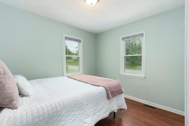 4121 Quebec St, Auburn Hills, MI 48326 - bedroom with wood finished floors, multiple windows, baseboards, and a textured ceiling
