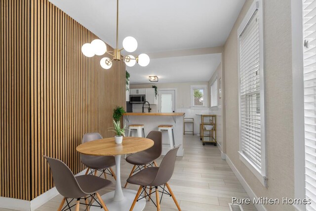 912 Arianna St NW, Grand Rapids, MI 49504 - dining room featuring light wood-type flooring, baseboards, and a chandelier