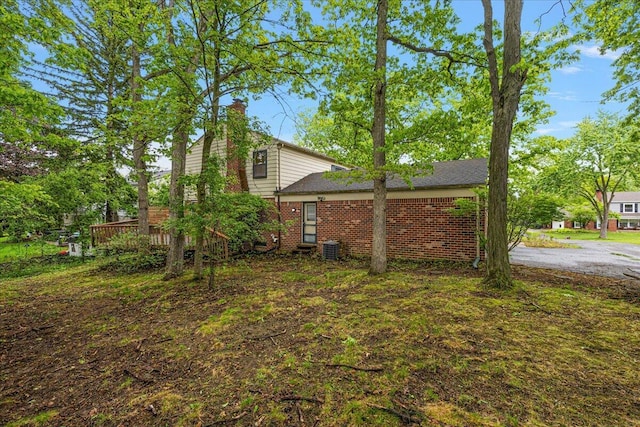 4948 Hardwoods Dr, West Bloomfield, MI 48323 - view of side of property featuring a chimney, brick siding, and central air condition unit