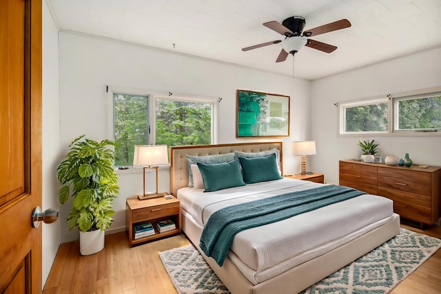 4771 S Lakeshore Dr, Ludington, MI 49431 - bedroom with multiple windows, light wood-style floors, and a ceiling fan