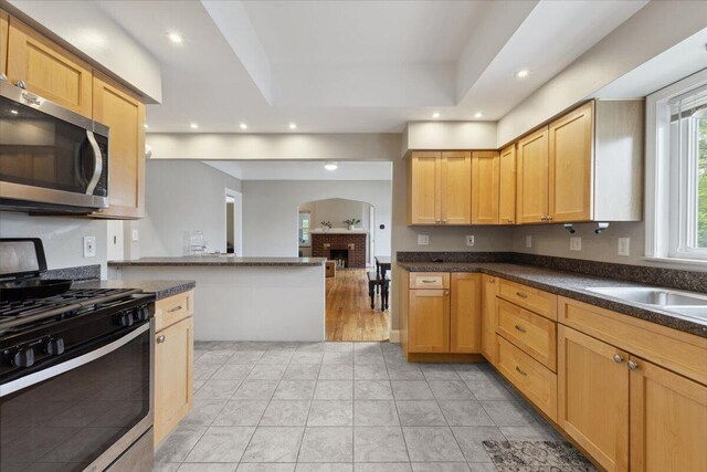 3364 Inman St, Ferndale, MI 48220 - kitchen featuring stainless steel appliances, arched walkways, recessed lighting, dark countertops, and light brown cabinetry