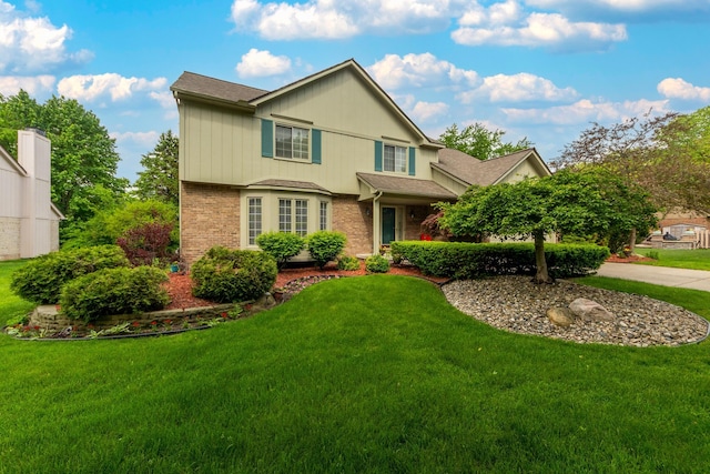 24609 Redwing Dr, Novi, MI 48374 - traditional-style home with brick siding, a front yard, and a shingled roof