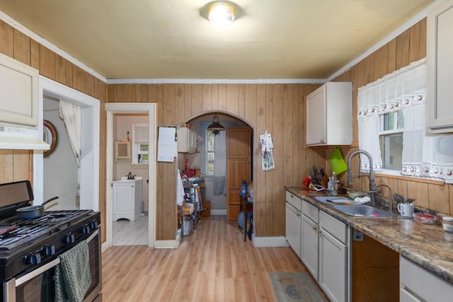 2113 Palace Ave SW, Grand Rapids, MI 49507 - kitchen featuring stainless steel range with gas stovetop, arched walkways, light wood-style floors, a sink, and under cabinet range hood
