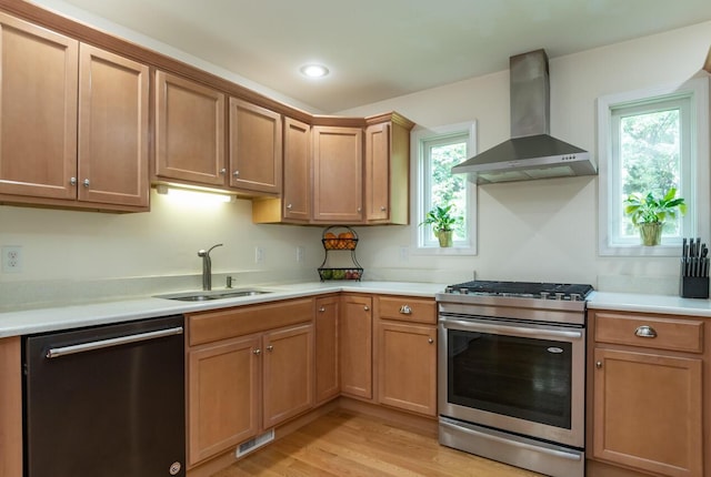 2501 Holiday House Rd, Saint Joseph, MI 49085 - kitchen featuring stainless steel appliances, wall chimney range hood, a sink, light countertops, and light wood-style flooring
