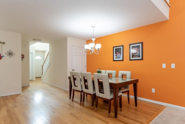 2501 Holiday House Rd, Saint Joseph, MI 49085 - dining room featuring a chandelier, baseboards, stairway, and light wood-style floors