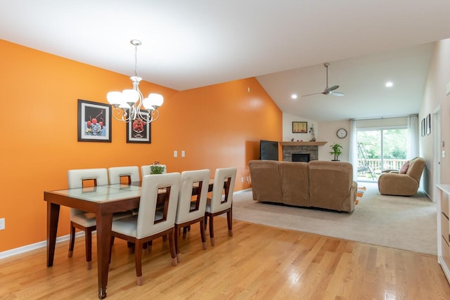 2501 Holiday House Rd, Saint Joseph, MI 49085 - dining space with a ceiling fan, light wood-type flooring, a chandelier, a fireplace, and lofted ceiling