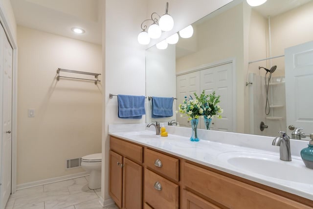 2501 Holiday House Rd, Saint Joseph, MI 49085 - full bathroom featuring toilet, double vanity, marble look tiles, baseboards, and a shower