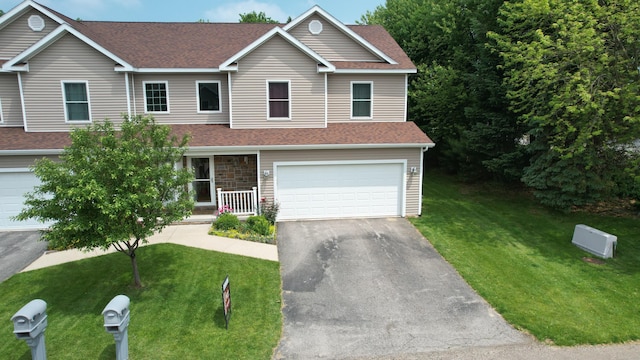 2501 Holiday House Rd, Saint Joseph, MI 49085 - view of front of house featuring driveway, a garage, a front lawn, and roof with shingles