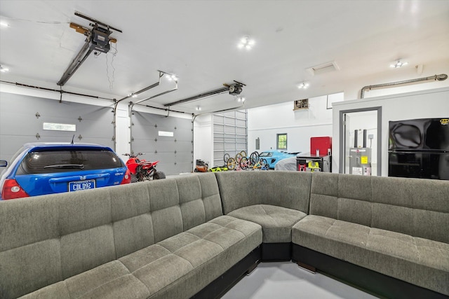 904 Schuring Rd, Portage, MI 49024 - garage featuring freestanding refrigerator, a garage door opener, and electric water heater