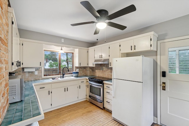 904 Schuring Rd, Portage, MI 49024 - kitchen with freestanding refrigerator, under cabinet range hood, a sink, stainless steel range with electric cooktop, and backsplash