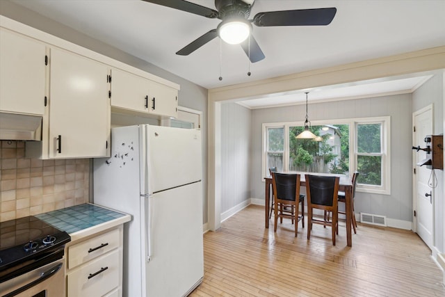 904 Schuring Rd, Portage, MI 49024 - kitchen with freestanding refrigerator, electric range, backsplash, tile countertops, and range hood