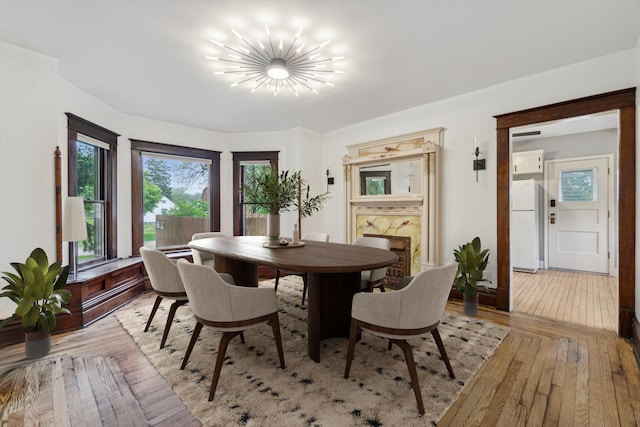 904 Schuring Rd, Portage, MI 49024 - dining area featuring light wood-style flooring, a chandelier, and a fireplace