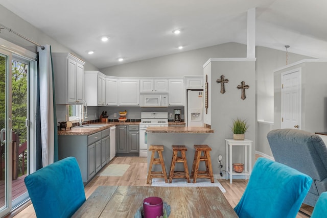 121 W Calgary Dr, Hastings, MI 49058 - kitchen with white appliances, vaulted ceiling, gray cabinetry, a sink, and light wood finished floors