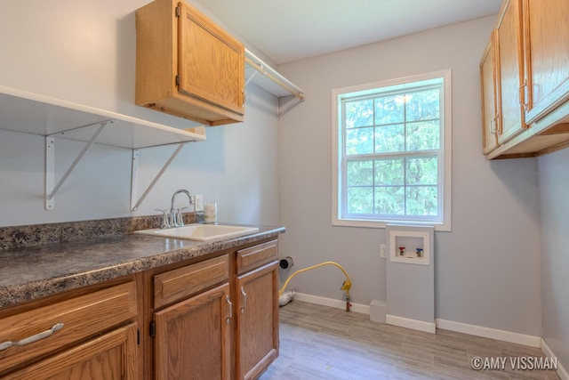 4175 Huntington Ave NE, Grand Rapids, MI 49525 - washroom featuring washer hookup, cabinet space, baseboards, and light wood finished floors
