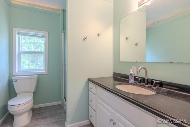 4175 Huntington Ave NE, Grand Rapids, MI 49525 - full bathroom with vanity, toilet, baseboards, wood finished floors, and a shower with shower door