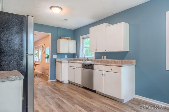 4175 Huntington Ave NE, Grand Rapids, MI 49525 - kitchen with stainless steel appliances, light wood-type flooring, a sink, and white cabinetry