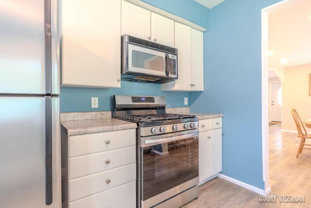 4175 Huntington Ave NE, Grand Rapids, MI 49525 - kitchen with stainless steel appliances, light countertops, light wood-style flooring, and baseboards