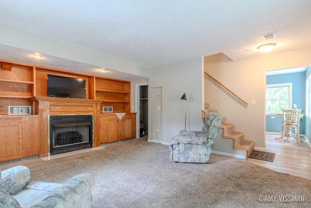 4175 Huntington Ave NE, Grand Rapids, MI 49525 - carpeted living area with stairs, baseboards, and a fireplace with flush hearth