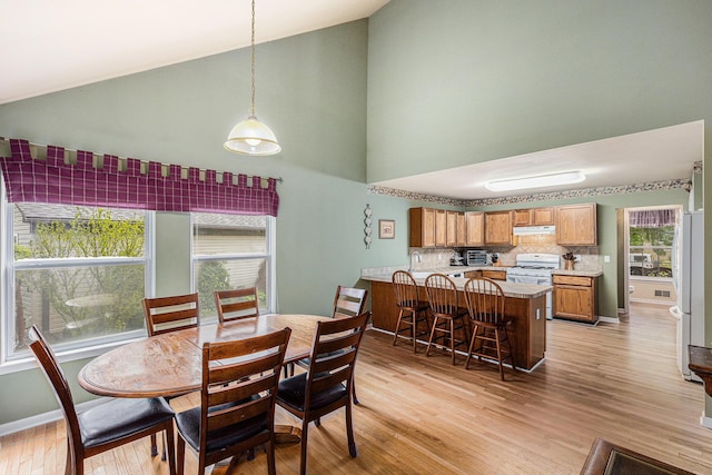 3311 Hickory Dr, Lake Orion, MI 48359 - dining space with high vaulted ceiling, light wood-style floors, and baseboards