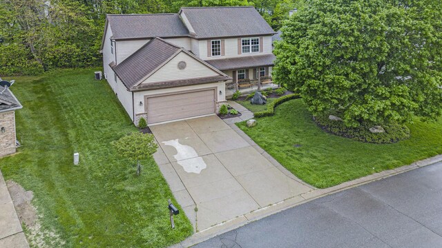 3311 Hickory Dr, Lake Orion, MI 48359 - traditional home featuring a front lawn, driveway, and an attached garage