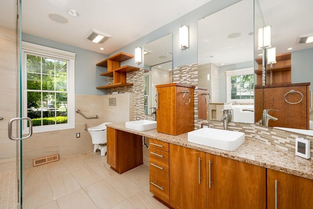 4936 Ravine Ct, Ann Arbor, MI 48105 - bathroom featuring healthy amount of natural light, vanity, a stall shower, backsplash, and tile walls