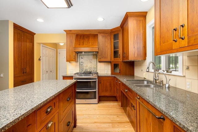 4936 Ravine Ct, Ann Arbor, MI 48105 - kitchen with double oven range, a sink, brown cabinets, stone countertops, and recessed lighting