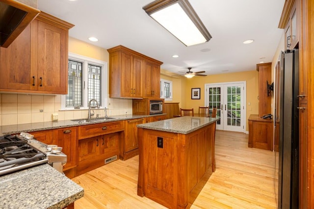 4936 Ravine Ct, Ann Arbor, MI 48105 - kitchen featuring a sink, brown cabinets, a center island, appliances with stainless steel finishes, and recessed lighting