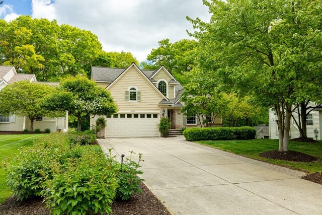 4936 Ravine Ct, Ann Arbor, MI 48105 - view of front facade with driveway, an attached garage, a front lawn, and brick siding