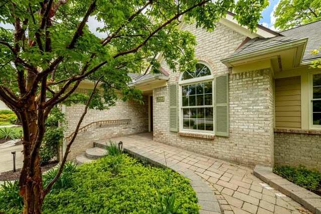 4936 Ravine Ct, Ann Arbor, MI 48105 - view of exterior entry with brick siding and roof with shingles
