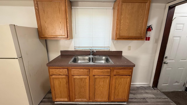 15852 Wabash St, Detroit, MI 48238 - kitchen featuring a sink, freestanding refrigerator, dark wood-style flooring, dark countertops, and baseboards