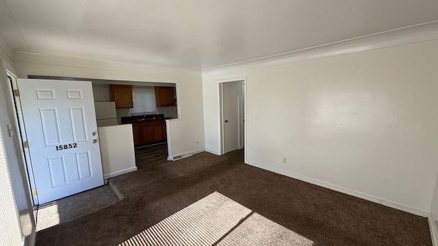 15852 Wabash St, Detroit, MI 48238 - unfurnished living room featuring dark carpet, baseboards, and a sink