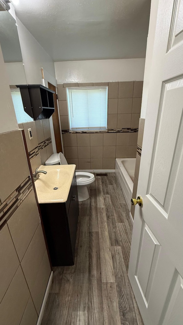 15852 Wabash St, Detroit, MI 48238 - full bathroom featuring toilet, tile walls, wood finished floors, vanity, and a bathtub