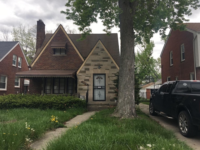 16510 Oakfield Ave, Detroit, MI 48235 - tudor home with a chimney, stone siding, and brick siding