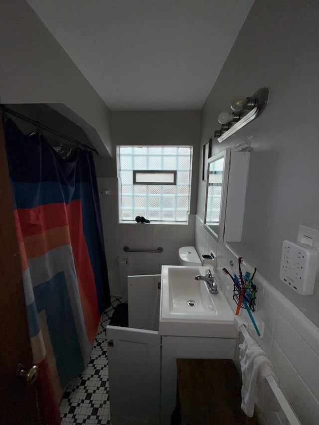 16510 Oakfield Ave, Detroit, MI 48235 - bathroom featuring tile walls, a shower with shower curtain, a wainscoted wall, and vanity