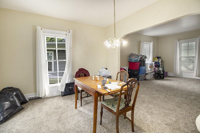 244 W Franklin St, Otsego, MI 49078 - carpeted dining area with a chandelier, arched walkways, and baseboards