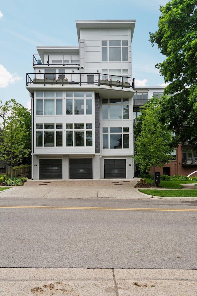 211 W Kingsley St, Ann Arbor, MI 48103 - back of property featuring a balcony, an attached garage, and driveway