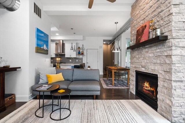 211 W Kingsley St, Ann Arbor, MI 48103 - living room featuring dark wood-type flooring, a stone fireplace, ceiling fan, and baseboards