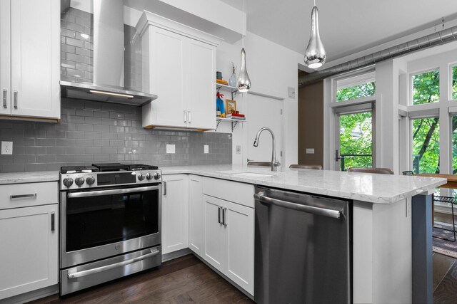 211 W Kingsley St, Ann Arbor, MI 48103 - kitchen featuring stainless steel appliances, wall chimney exhaust hood, a sink, a peninsula, and white cabinetry