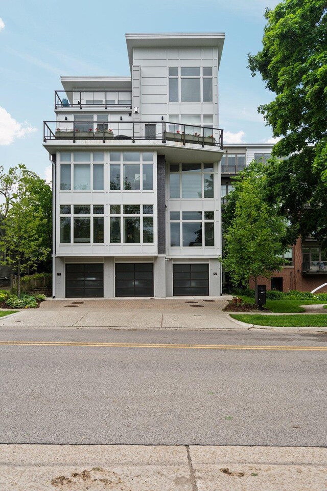 211 W Kingsley St, Ann Arbor, MI 48103 - back of property featuring a balcony, an attached garage, and driveway