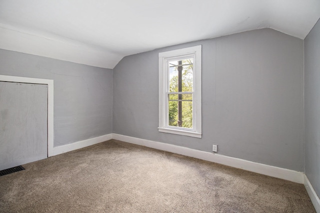 527 Jackson St W, Battle Creek, MI 49037 - additional living space with vaulted ceiling, carpet flooring, and baseboards