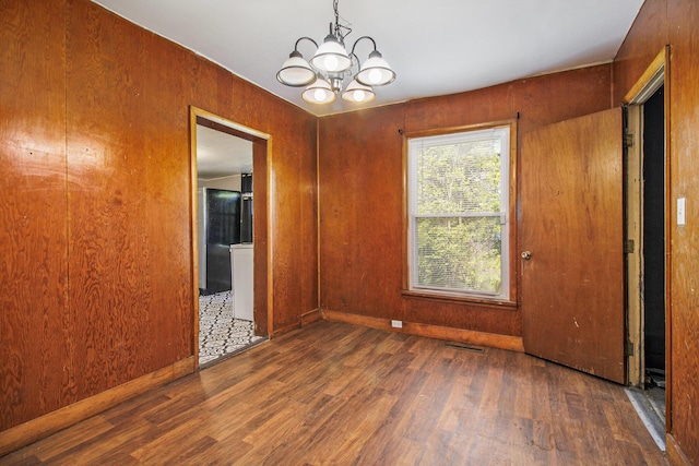 527 Jackson St W, Battle Creek, MI 49037 - empty room featuring wood finished floors and a chandelier