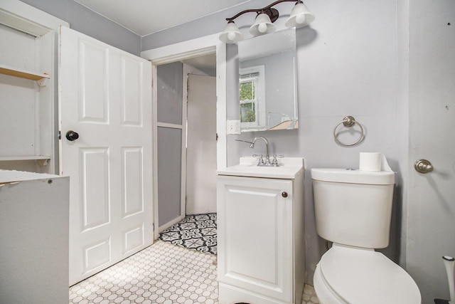 527 Jackson St W, Battle Creek, MI 49037 - bathroom featuring toilet, vanity, and tile patterned floors