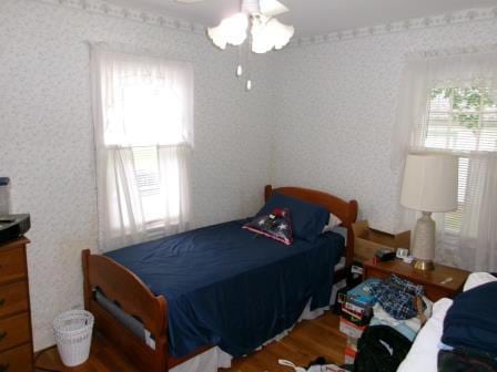 98 Reading Ave, Hillsdale, MI 49242 - bedroom with wood finished floors, wallpapered walls, and a ceiling fan
