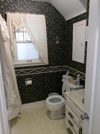 98 Reading Ave, Hillsdale, MI 49242 - full bathroom with vanity, toilet, tile patterned floors, and vaulted ceiling